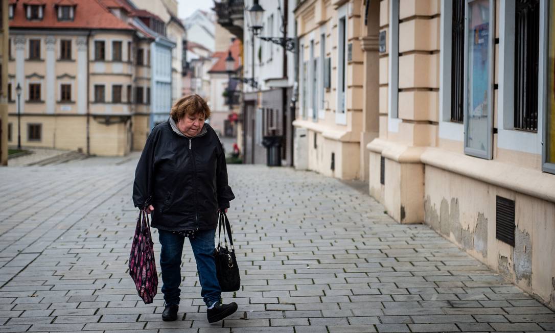 Mulher carrega sacolas de compras no centro de Bratislava.A Eslováquia declarou um lockdown de duas semanas após aumento nos casos de COVID-19, devido à nova variante ômicron Foto: VLADIMIR SIMICEK / AFP