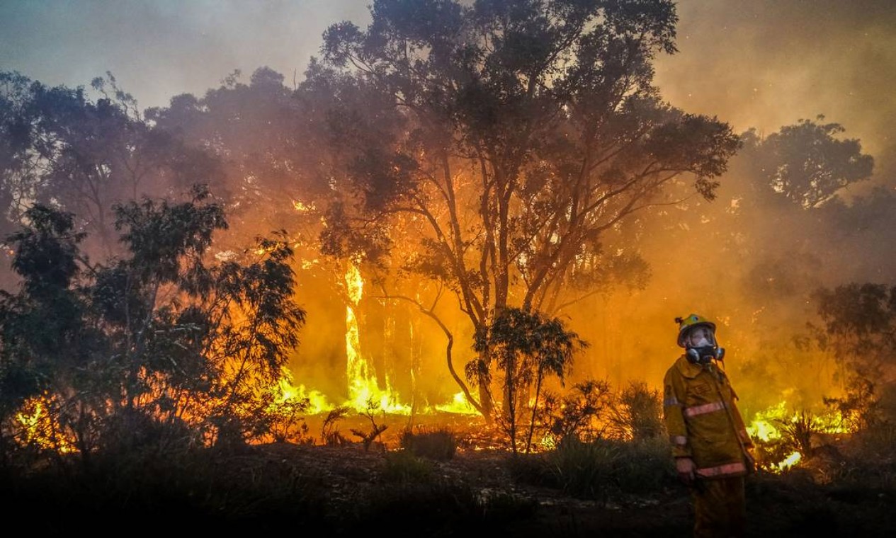 Bombeiro trabalha no combate às chamas em um incêndio florestal perto de Margaret River, Austrália Foto: SEAN BLOCKSIDGE / AFP