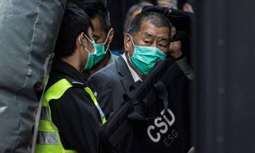 Magnata da mídia de Hong Kong, Jimmy Lay é escoltado do lado de fora de um tribunal em fevereiro de 2021 Foto: STR / AFP