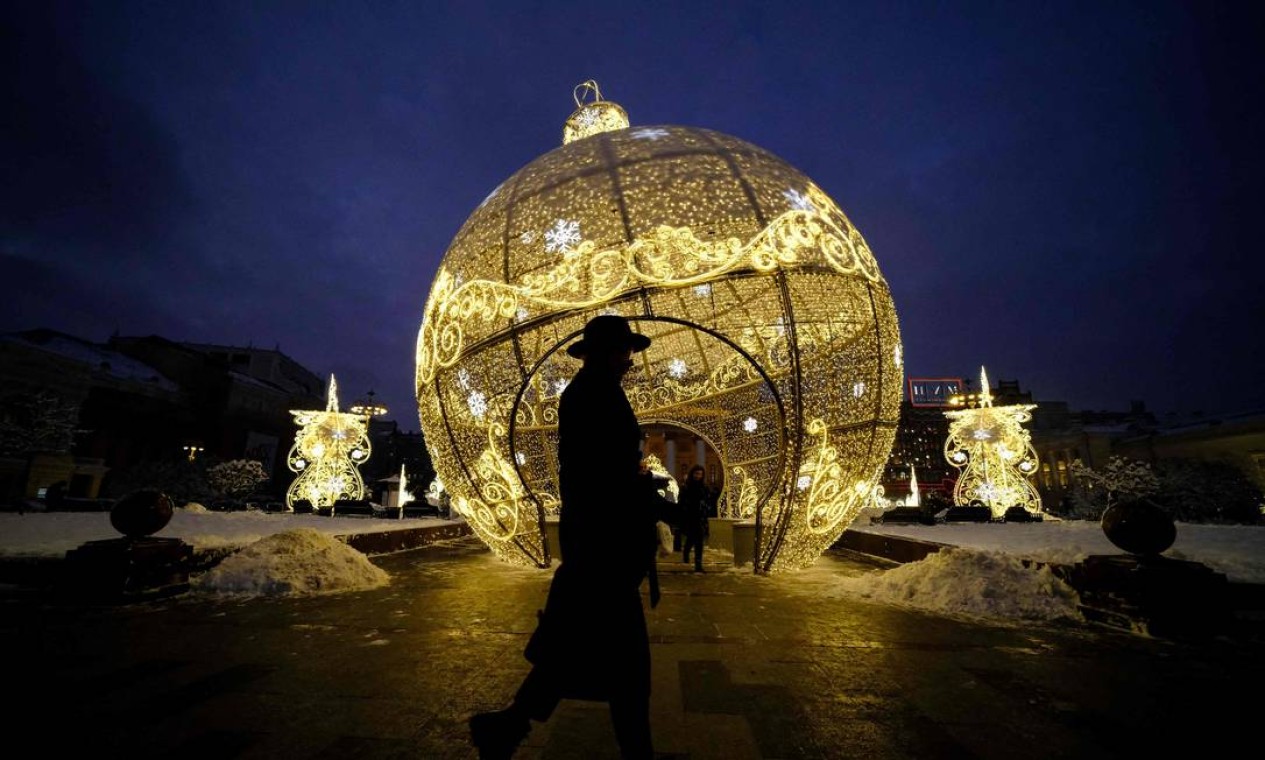 Pedestre passa por decorações de Natal em frente ao Teatro Bolshoi, no centro de Moscou, Rússia Foto: YURI KADOBNOV / AFP