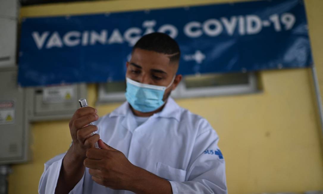 Profissional de saúde prepara dose de vacina contra Covid em posto montado na estação de BRT do Recreio no Rio Foto: MAURO PIMENTEL / AFP/28-10-2021