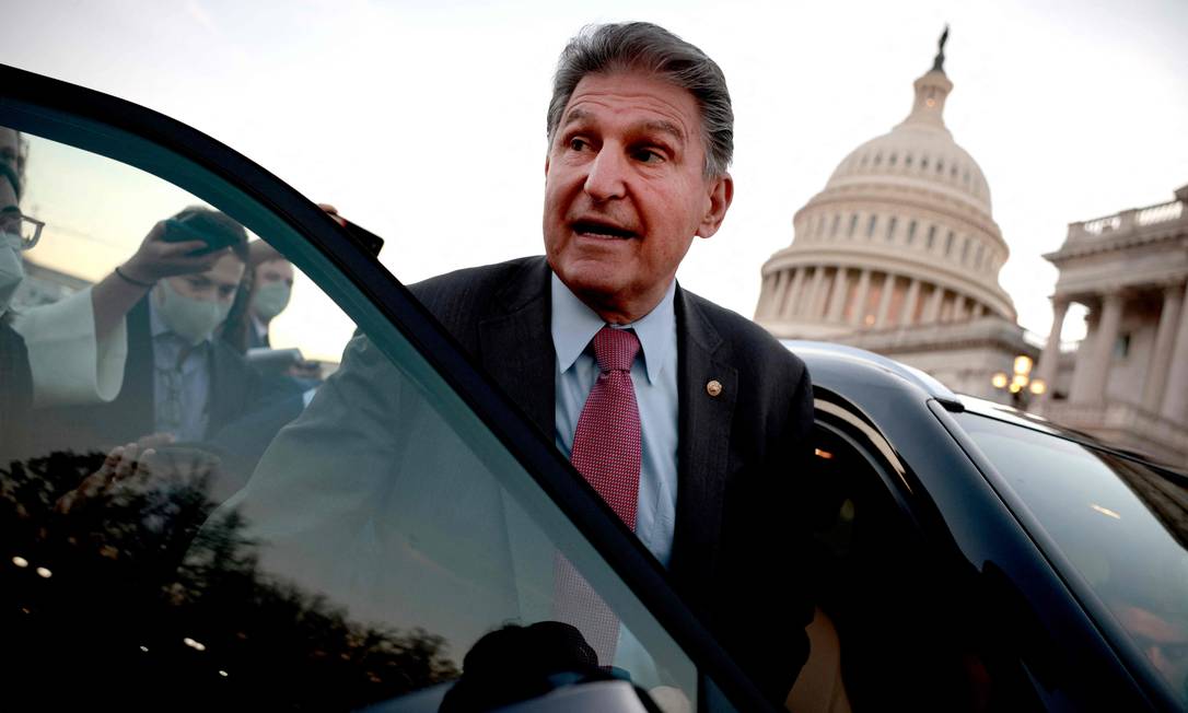 Senador democrata Joe Manchin, da Virgínia Ocidental, é seguido até seu carro por repórteres em Washington, DC Foto: ANNA MONEYMAKER / AFP