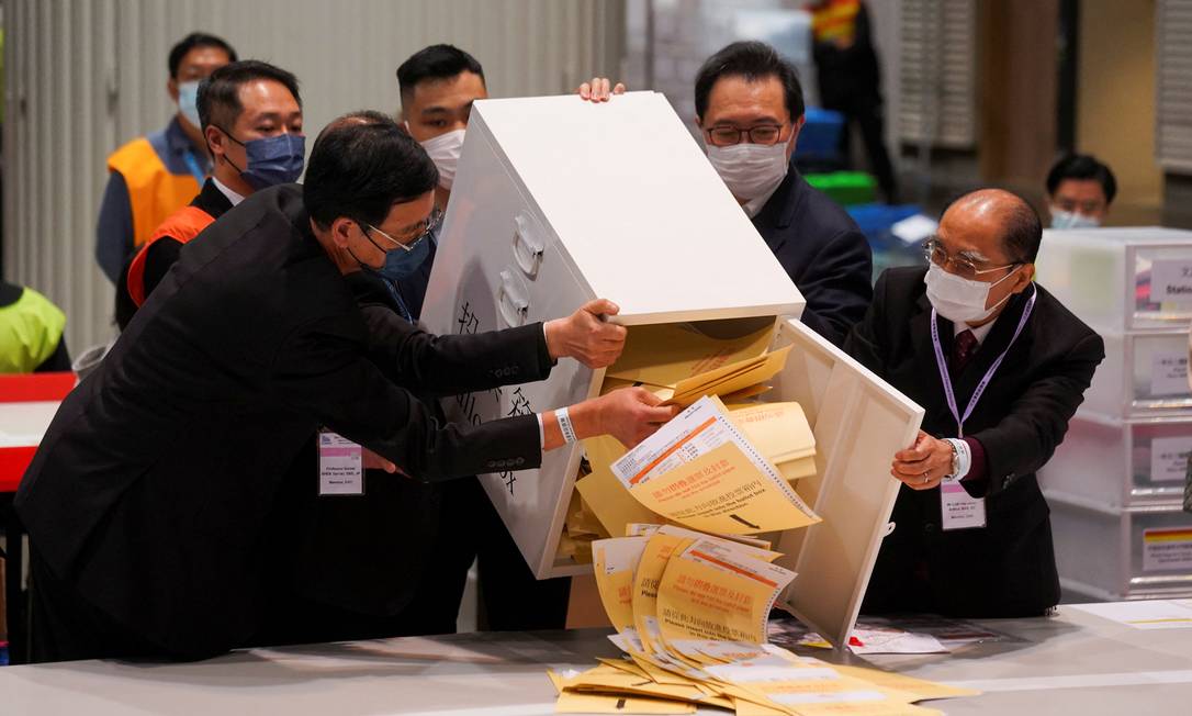 O presidente da Comissão de Assuntos Eleitorais, Barnabas Fung Wah, abrem as urnas para a eleição do Conselho Legislativo em um centro de contagem de votos, em Hong Kong Foto: LAM YIK / REUTERS