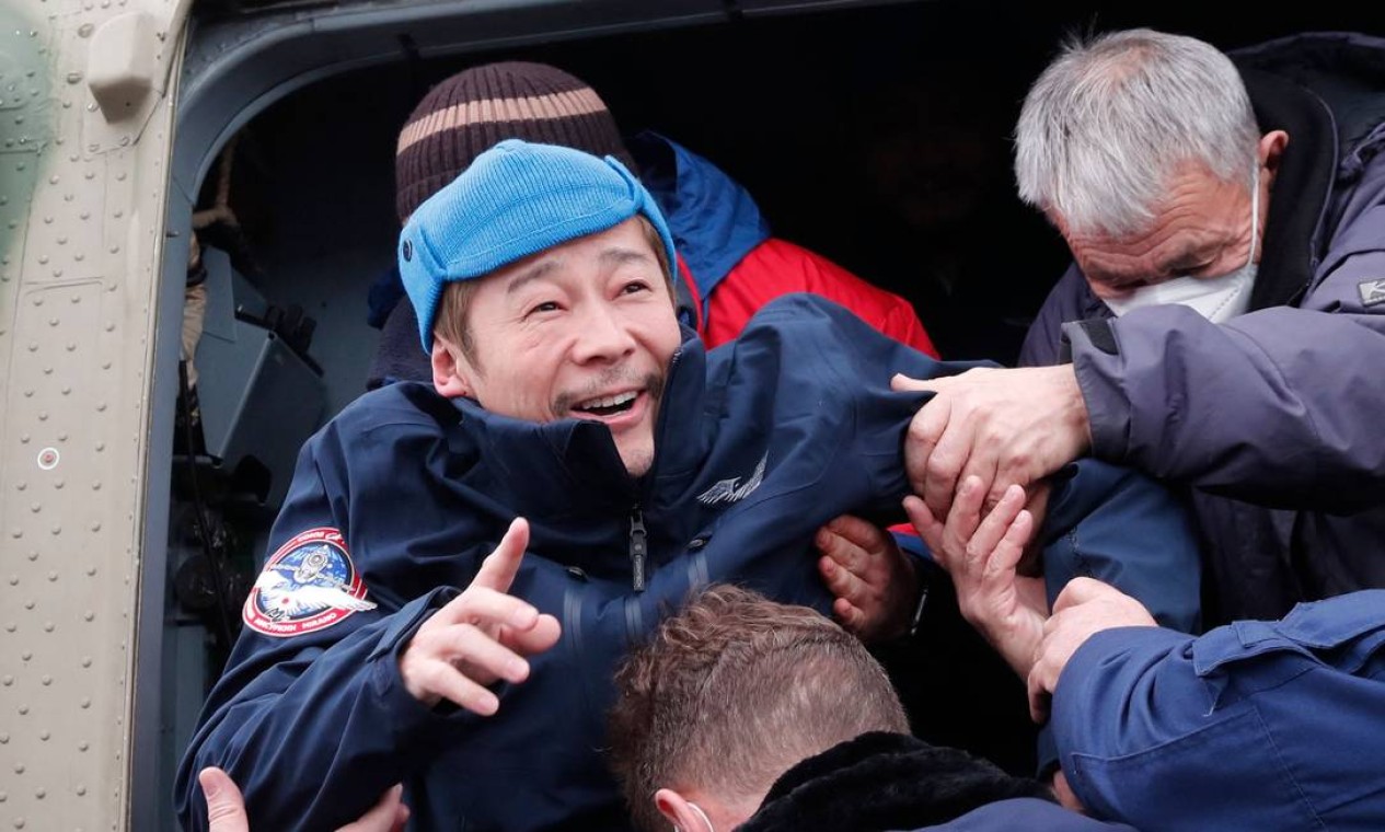 O bilionário japonês Yusaku Maezawa é ajudado a desembarcar de um helicóptero ao chegar ao aeroporto de Zhezkazgan, após retornar da Estação Espacial Internacional (ISS), na cápsula espacial Soyuz MS-20, em Zhezkazgan, Cazaquistão. O bilionário voltou à Terra na segunda-feira, após 12 dias na Estação Espacial Internacional Foto: SHAMIL ZHUMATOV / AFP