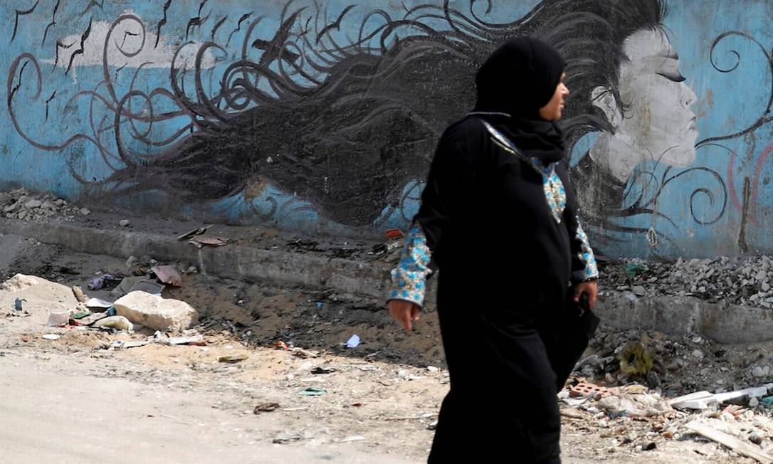 Uma mulher passa por um mural com uma mensagem contra assédio sexual em uma rodovia em Cairo Foto: Amr Abdallah Dalsh / Reuters