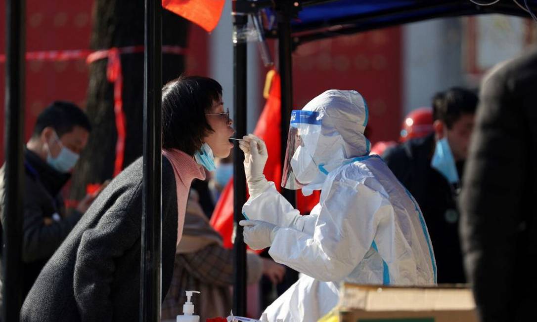 Mulher faz teste de Covid-19 em Xian, na China, em meio a quarentena estipulada na cidade para conter avanço das infecções Foto: AFP / CHINA OUT