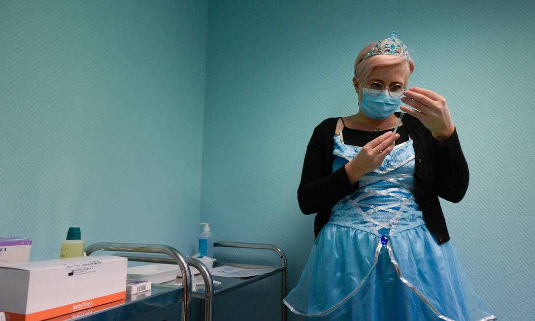 Profissional de saúde vestida de princesa prepara dose para vacinar crianças na França Foto: SEBASTIEN BOZON / AFP