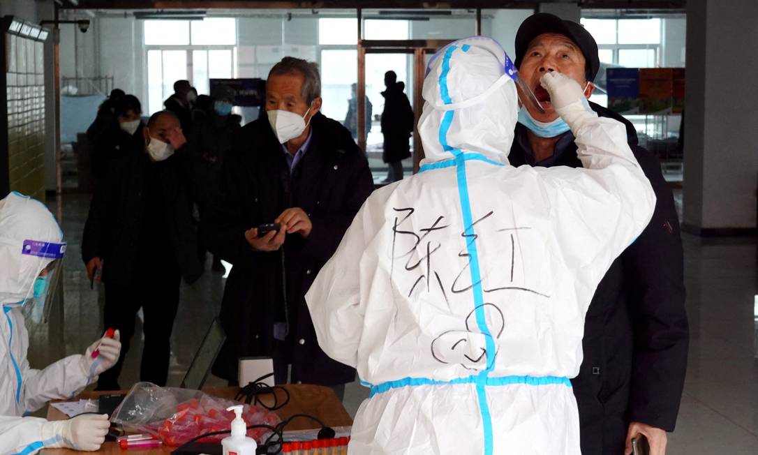 Enfermeiro coleta uma amostra durante outra rodada de testes em massa após o surto de Covid em Xi'an, na China Foto: STRINGER / VIA REUTERS