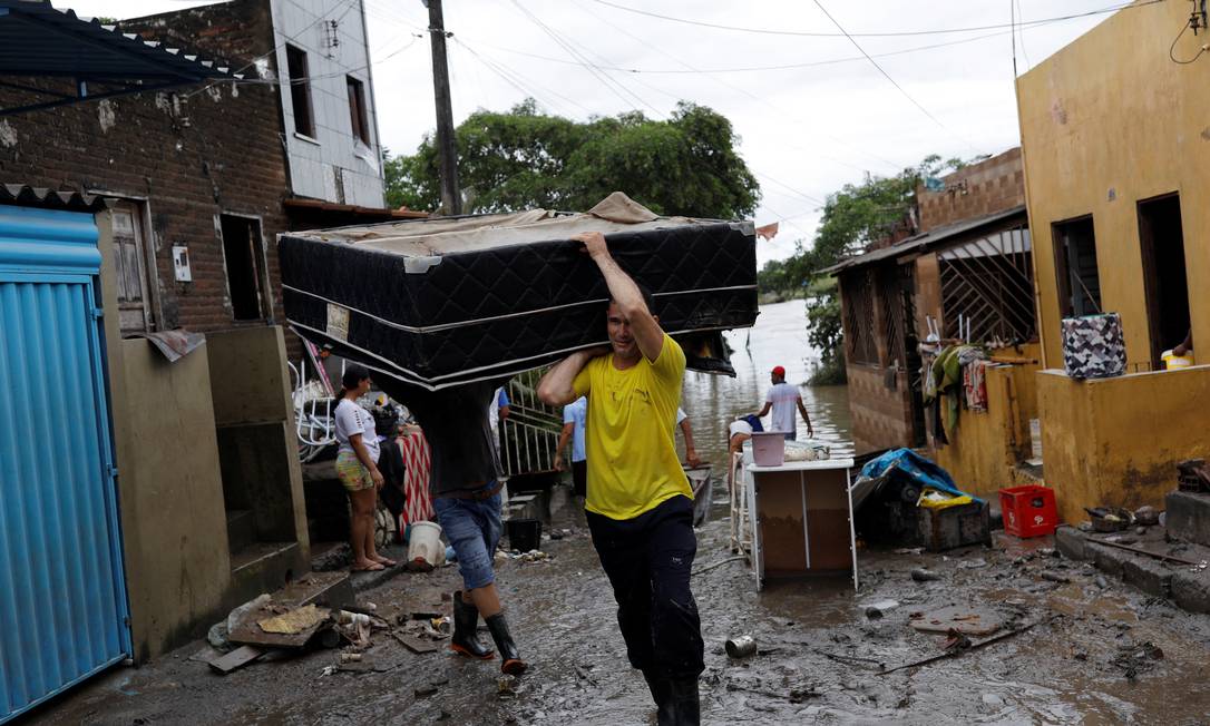Jose Eldes carries his brother's bed, during floods caused due to heavy rains, in Itabuna, Bahia state, Brazil December 27, 2021. REUTERS/Amanda Perobelli Foto: AMANDA PEROBELLI / REUTERS