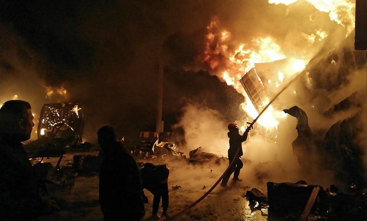 Bombeiros lutam contra incêndio no porto de Latakia, na Síria, após um ataque aéreo israelense Foto: - / AFP