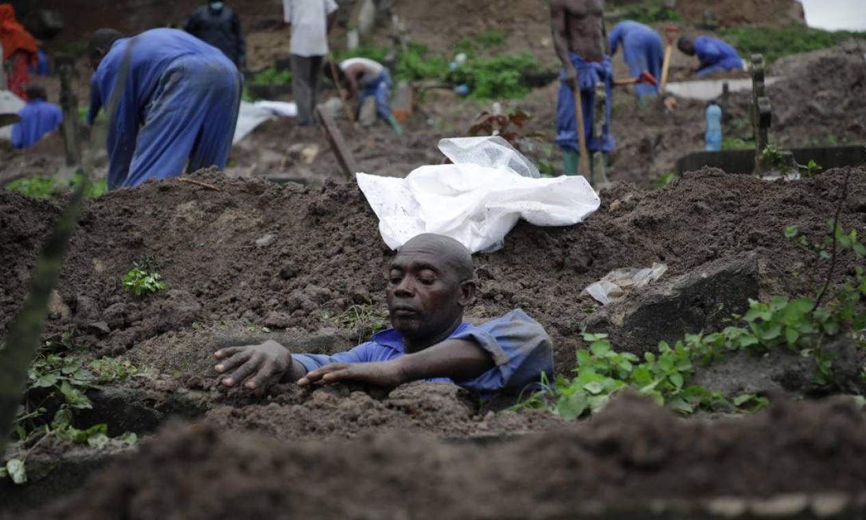Homem coleta restos mortais de um túmulo no cemitério Vingunguti, em Dar es Salaam, Tanzânia, durante a transferência de 200 túmulos para Kitunda Mwanagati Foto: ERICKY BONIPHACE / AFP