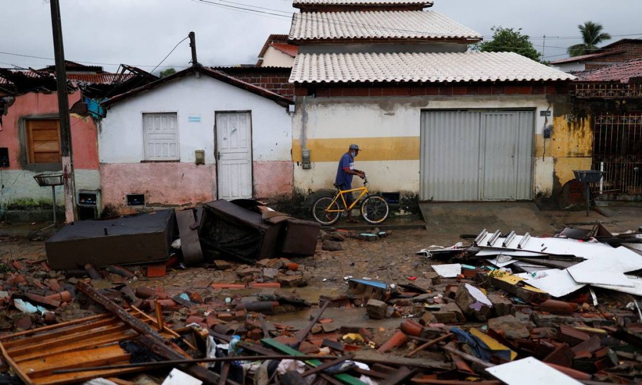 Homem passa por escombros de casas de um bairro em Itambé. Cidades inteiras foram alagadas Foto: AMANDA PEROBELLI / REUTERS