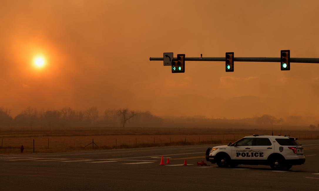 Um carro da polícia vigia região tomada pela fumaça do incêndio florestal em Boulder, no Colorado Foto: KEVIN MOHATT / REUTERS