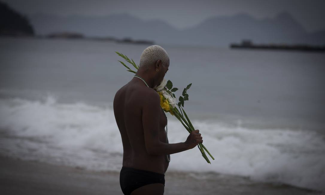 Homem joga flores no mar de Copacabana no ltimo dia do ano Foto: Marcia Foletto / Agncia O Globo