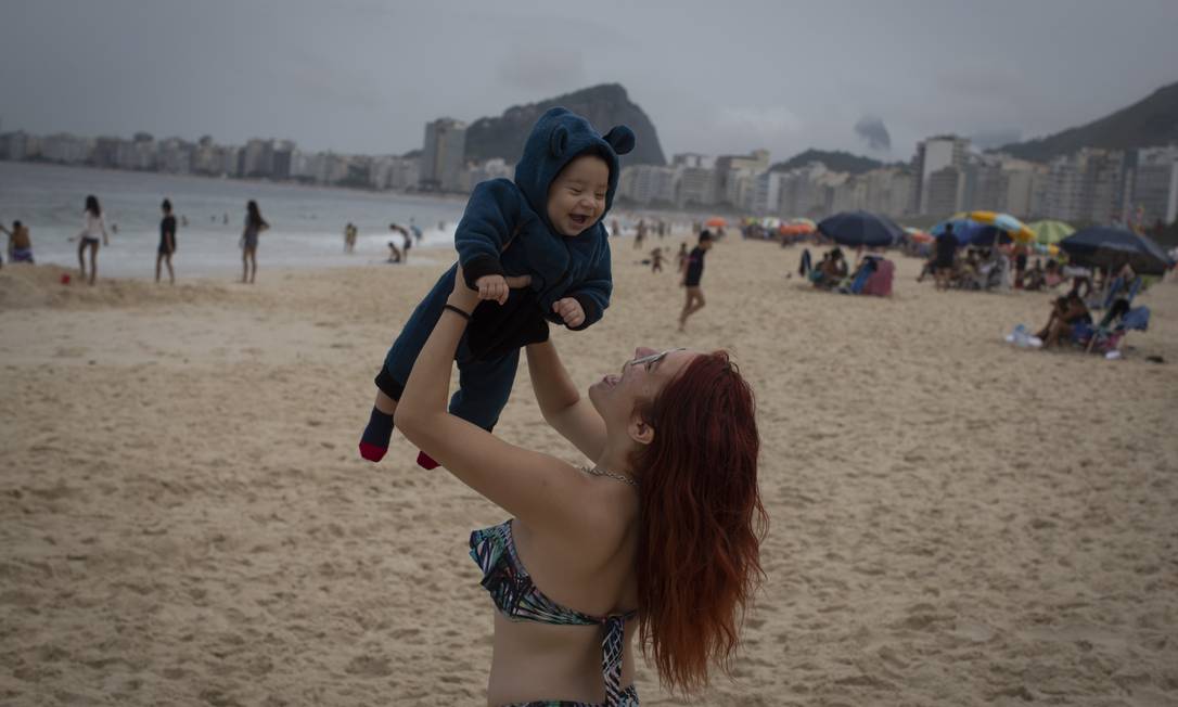 Turista brinca com o filho na praia de Copacabana antes da virada do ano Foto: Marcia Foletto / Agência O Globo