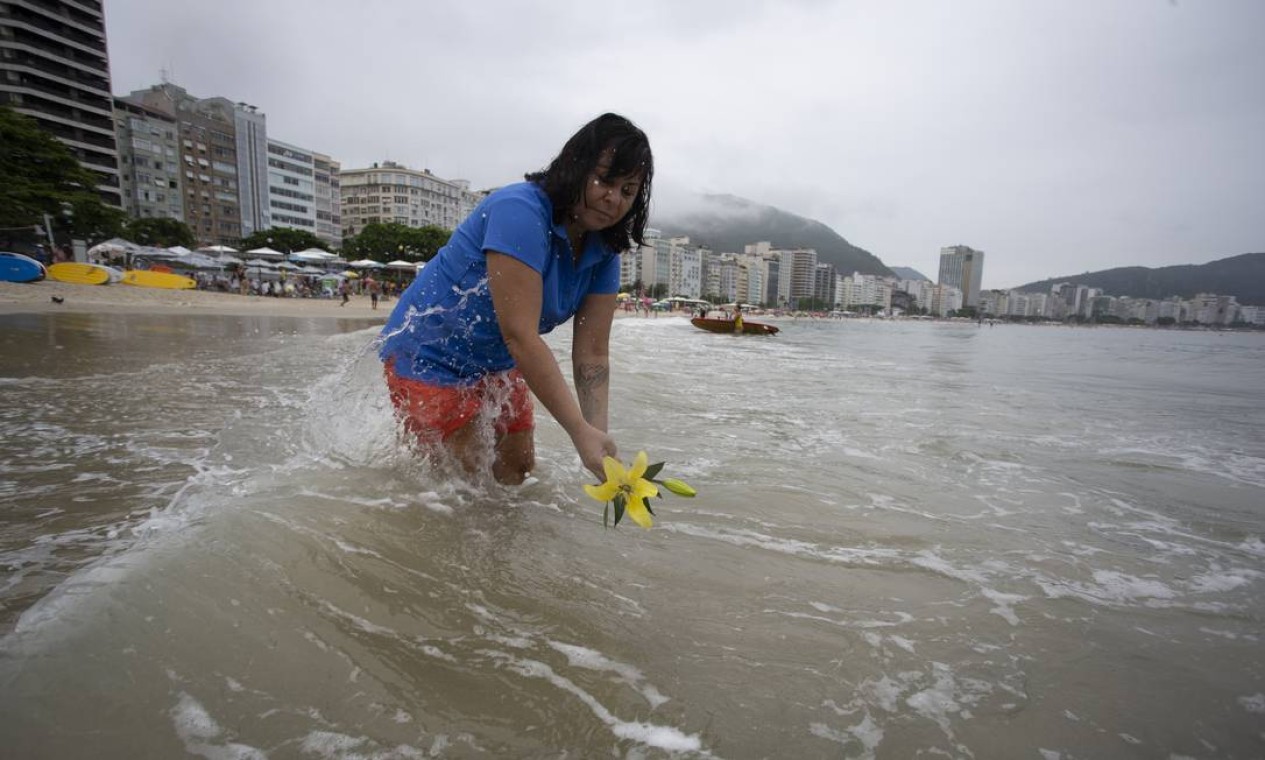 Mulher lança flores ao mar em Copacabana para pedir boas vibrações para o novo ano Foto: Marcia Foletto / Agência O Globo