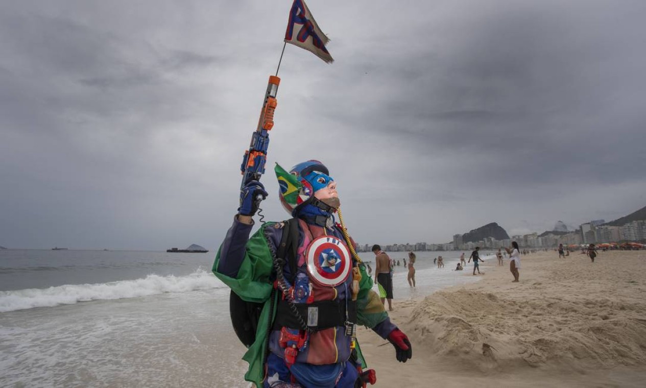 Homem vestido de Capitão Aranha na Praia de Copacabana faz oferendas a Iemanjá na véspara do ano novo Foto: Ana Branco / Agência O Globo