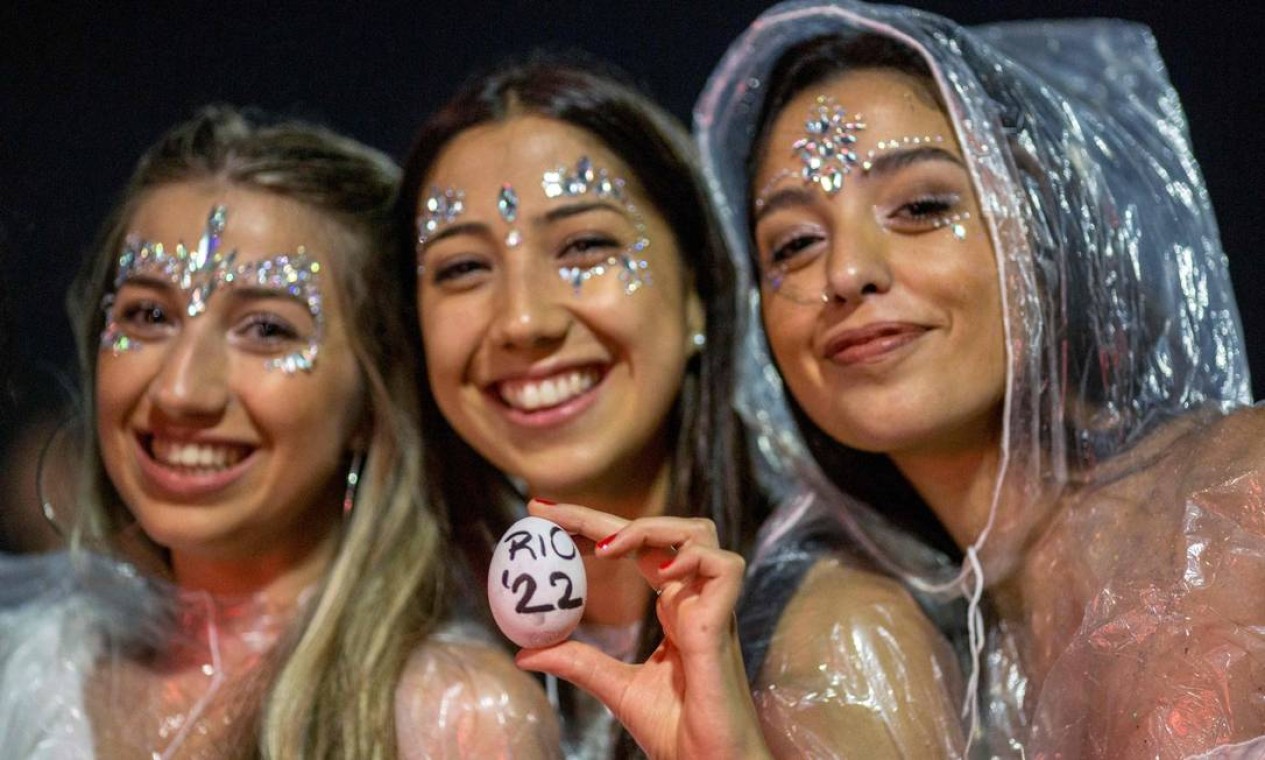 Com capas de chuva, amigas celebram o novo ano na Praia de Copacabana Foto: Daniel Ramalho / AFP