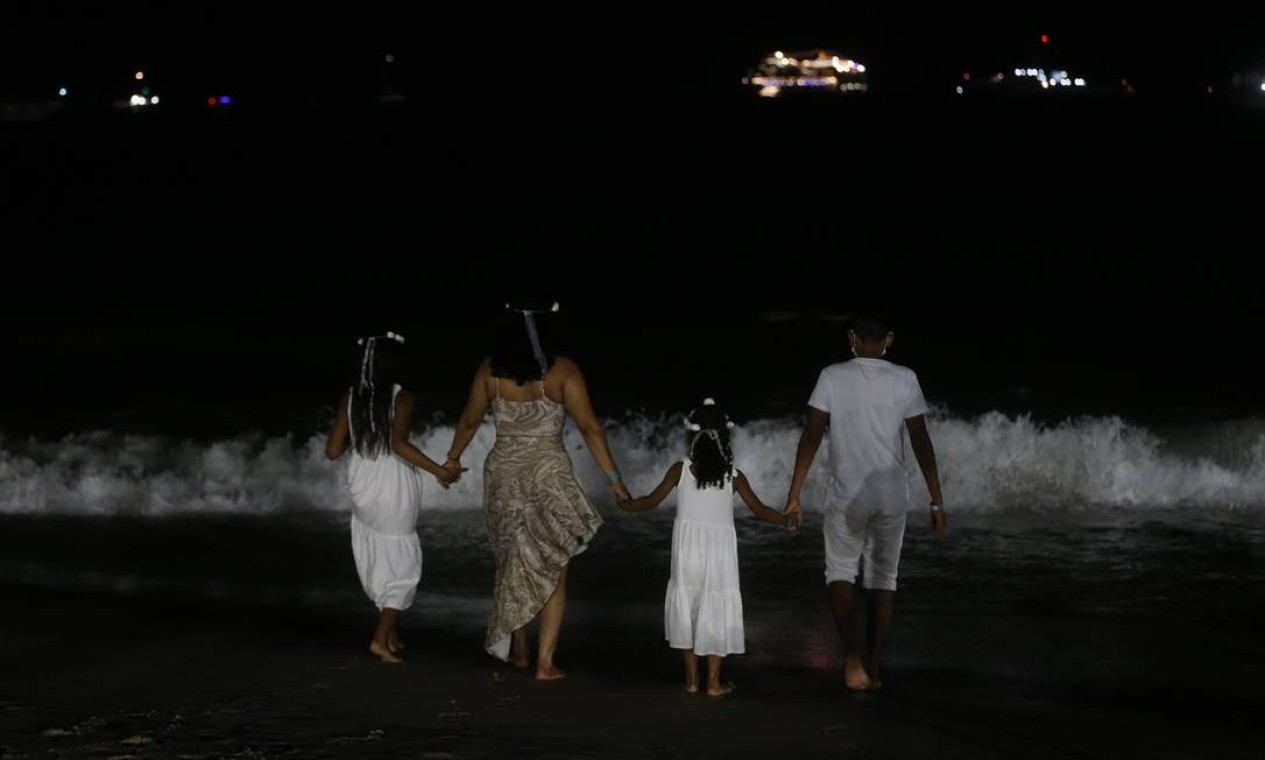 Apesar de não haver show e da chuva fina, muitas pessoas não abriram mão de virar o ano à beira-mar Foto: Roberto Moreyra / Agência O Globo
