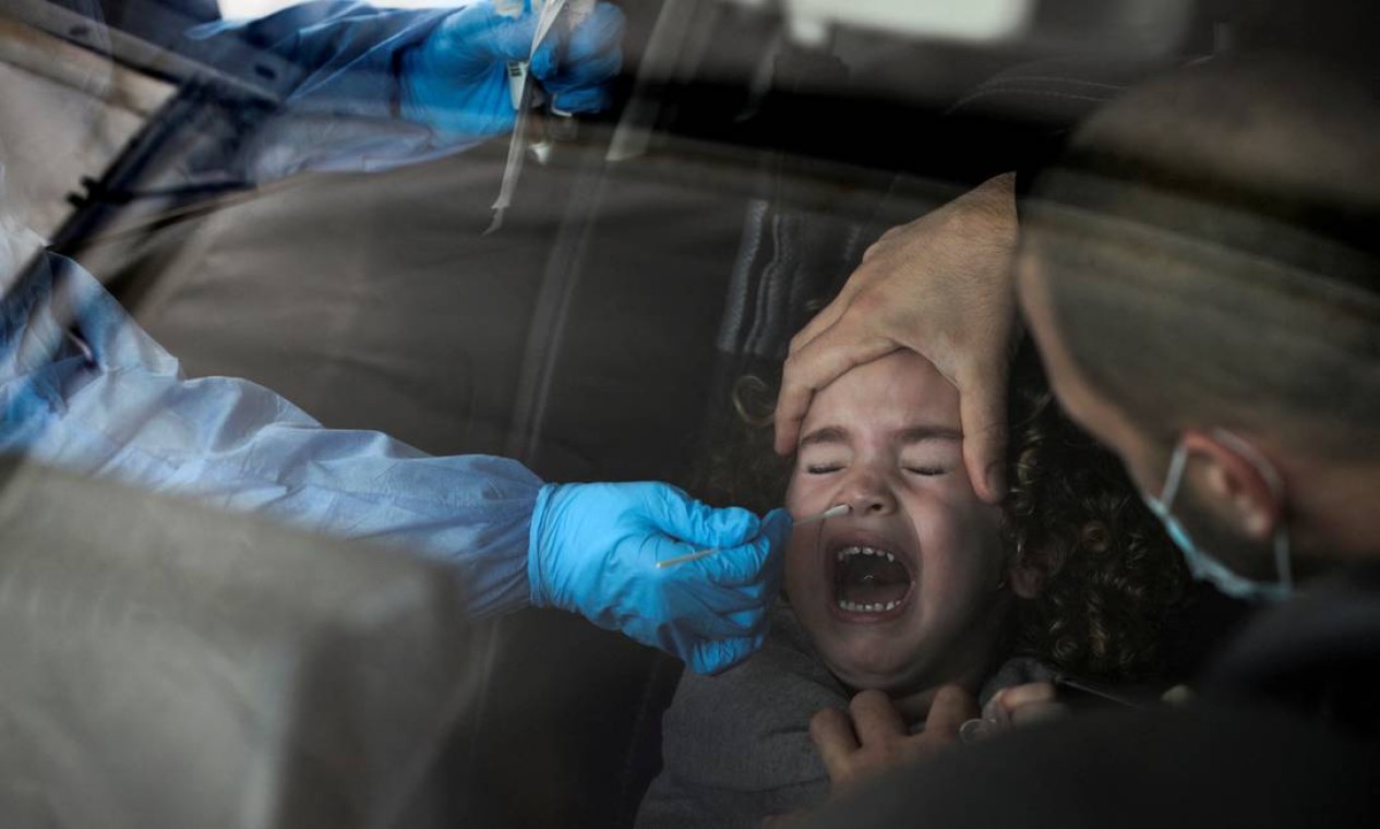 Menina passa por teste para covid-19 em um drive-thru, enquanto Israel enfrenta um aumento de infecções pela variante Ômicron, em Jerusalém Foto: AMMAR AWAD / REUTERS