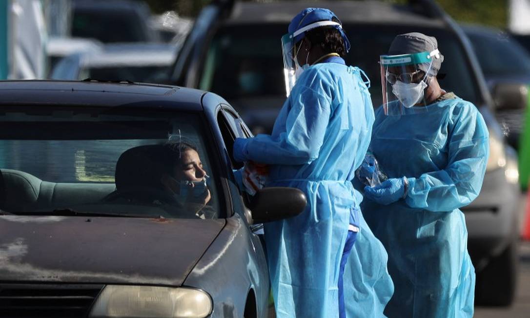 Em Miami, na Flórida, funcionários da saúde aplicam testes de Covid em drive-thru Foto: JOE RAEDLE / AFP