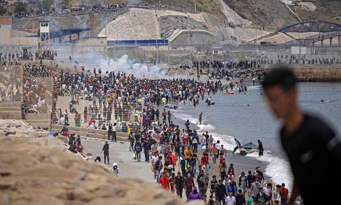 Polícia tenta dispersar migrantes marroquinos na região de Ceuta, na Espanha Foto: FADEL SENNA / AFP