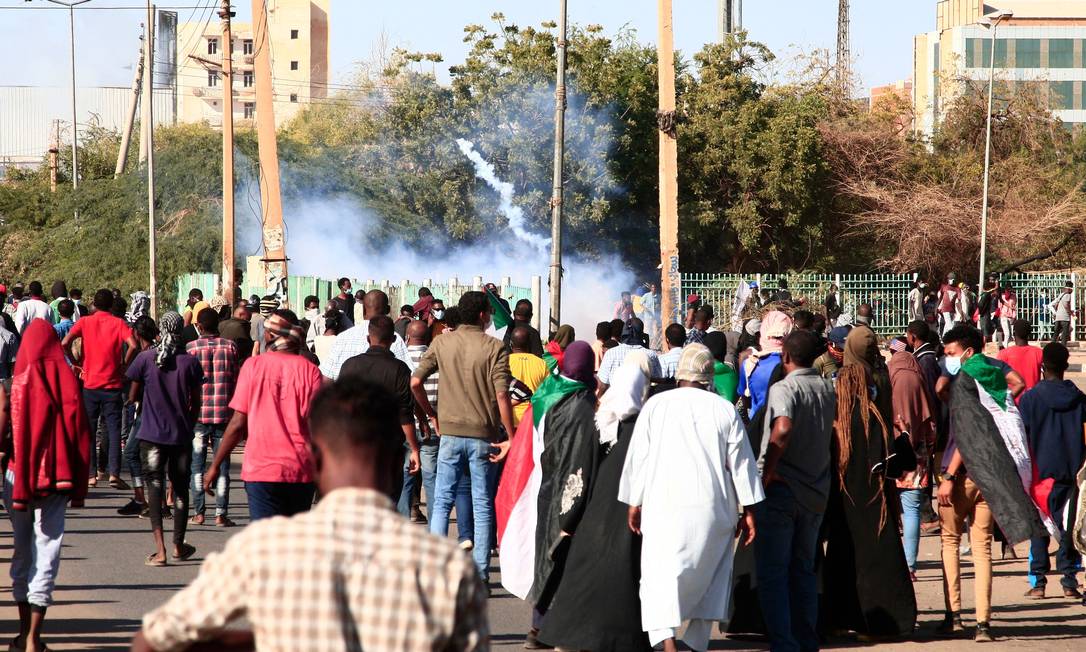 Manifestantes sudaneses queimam pneus durante protesto contra militares e a morte de civis em manifestações Foto: AFP