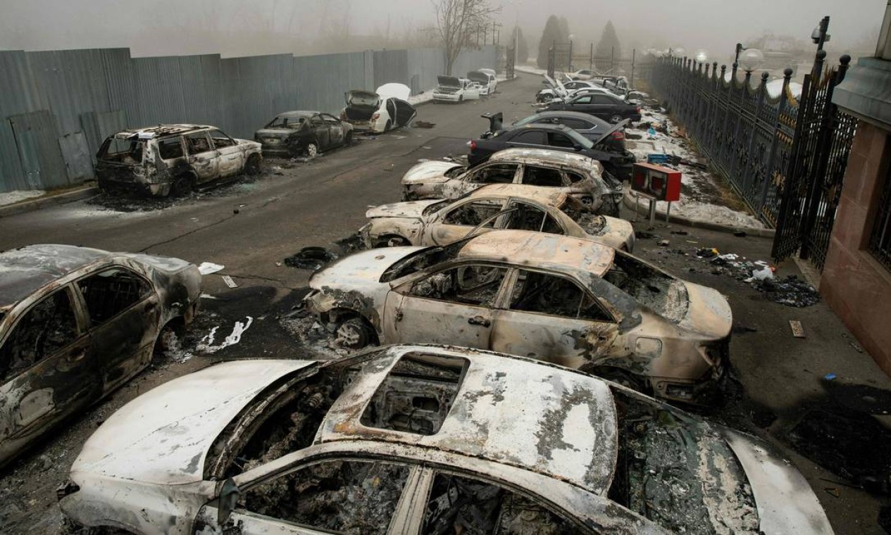 Carros queimados em um estacionamento no centro de Almaty. Confrontos já deixaram dezenas de mortos no país da Ásia Central Foto: ALEXANDER BOGDANOV / AFP