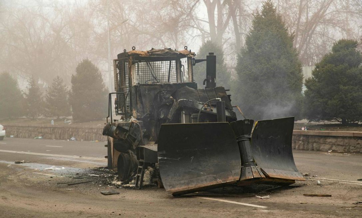 Escavadeira queimada é vista no centro de Almaty. Doze oficiais de segurança foram mortos e 353 feridos em protestos contínuos no Cazaquistão Foto: ALEXANDER BOGDANOV / AFP