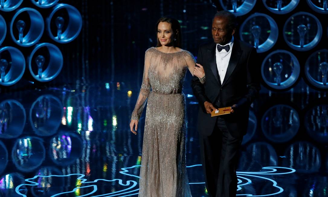 Poitier acompanhado de Angelina Jolie sobe ao palco para apresentar o Oscar em 2014 Foto: Lucy Nicholson / REUTERS