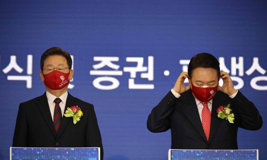 Yoon Suk-yeol (D), candidato do Partido do Poder do Povo, ao lado de Lee Jae-myung (E), nome do Partido Democrático à Presidência da Coreia do Sul, durante cerimônia de abertura do primeiro pregão do ano na Bolsa de Seul, no dia 3 de janeiro Foto: KIM HONG-JI / AFP