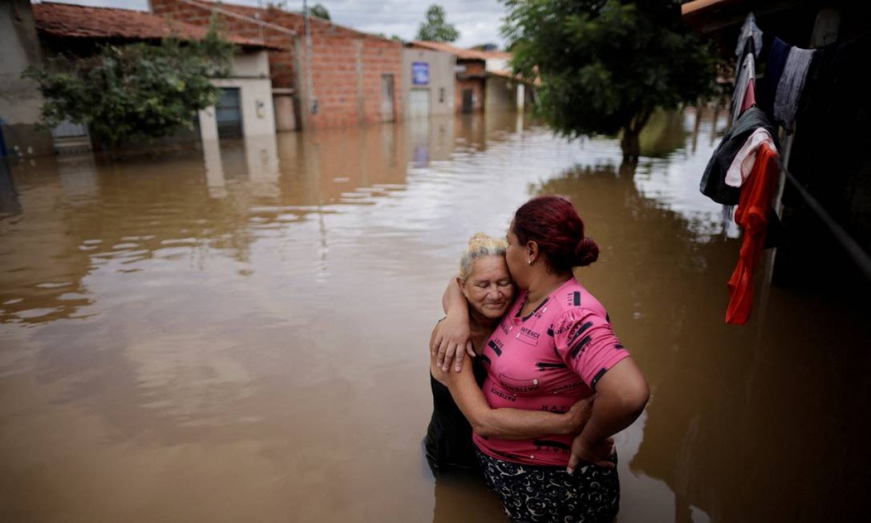 Mãe e filha se abraçam diante de casas inundadas durante enchentes em Imperatriz, no Maranhão Foto: UESLEI MARCELINO / REUTERS