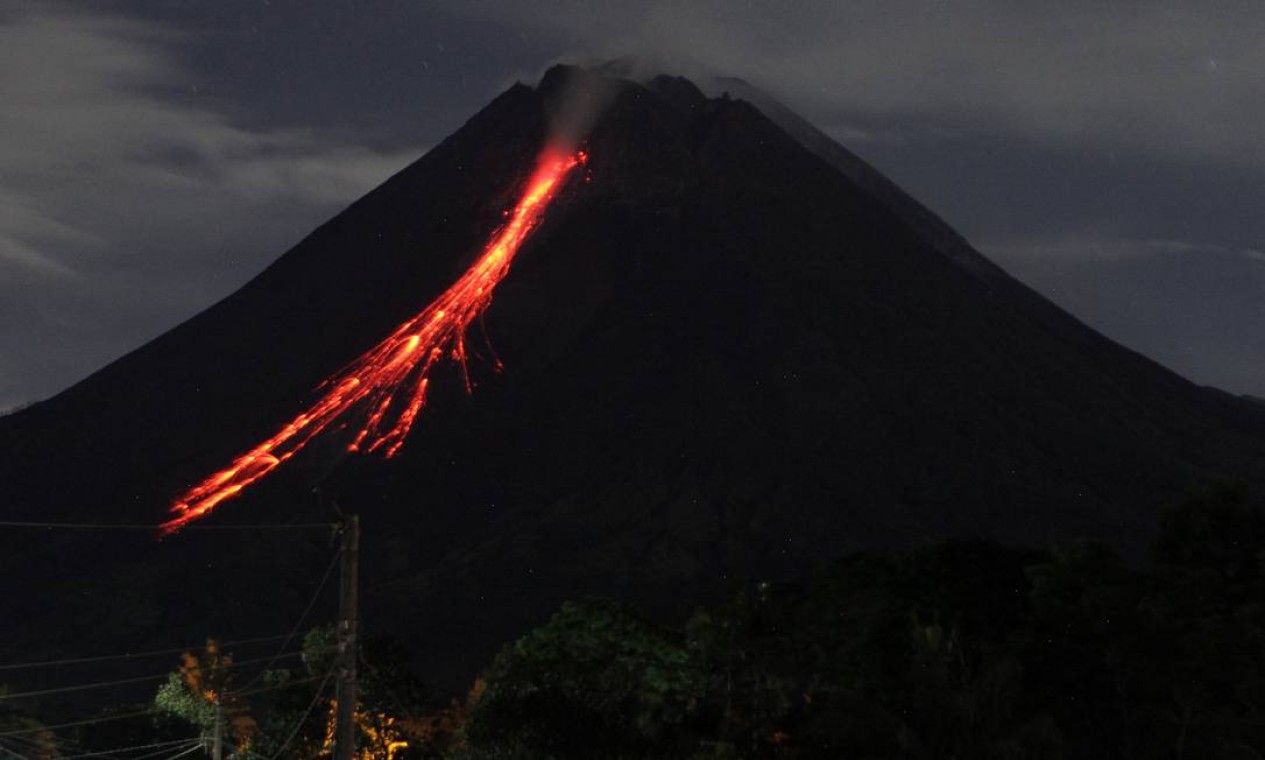 Monte Merapi, vulcão mais ativo da Indonésia, expele cinzas e lava de seu pico visto de Sleman, em Yogyakarta Foto: DEVI RAHMAN / AFP