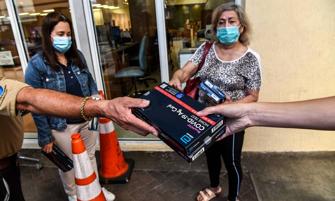 Funcionários de biblioteca pública de Miami distribuem kits de teste caseiro para a população na cidade americana. Foto: CHANDAN KHANNA / AFP