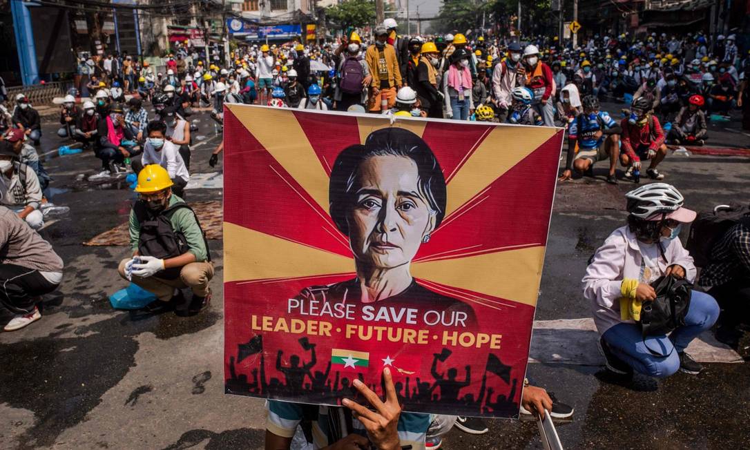 Manifestante carrega poster com rosto de Aung San Suu Kyi durante protestos em Yangon Foto: STR / AFP/2-3-21