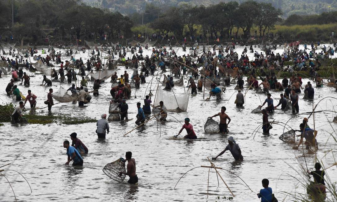 Aldeões participam de um evento de pesca comunitária no Lago Goroimari em Panbari, nos arredores de Guwahati, na Índia Foto: BIJU BORO / AFP