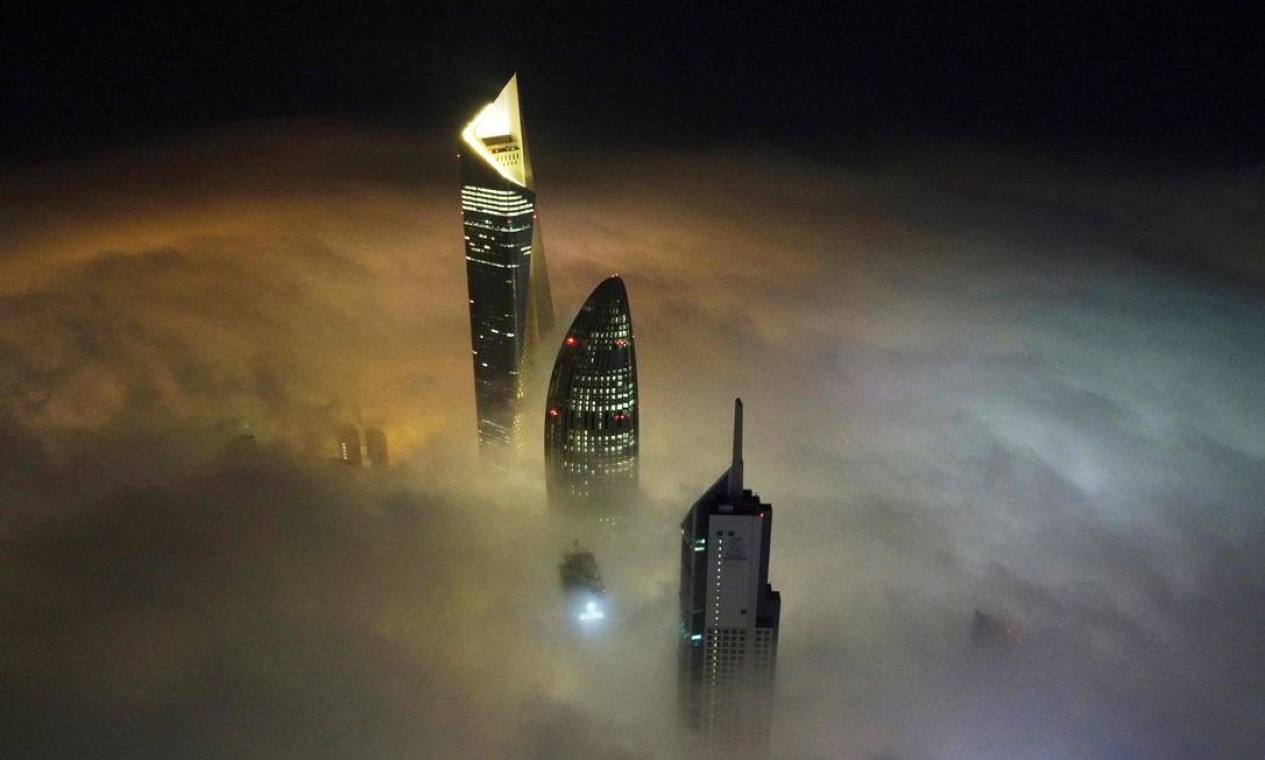 Forte neblina atinge a Cidade do Kuwait, deixando à mostra apenas as torres al-Hamra e al-Rayah e a sede do Banco Nacional do Kuwait Foto: YASSER AL-ZAYYAT / AFP