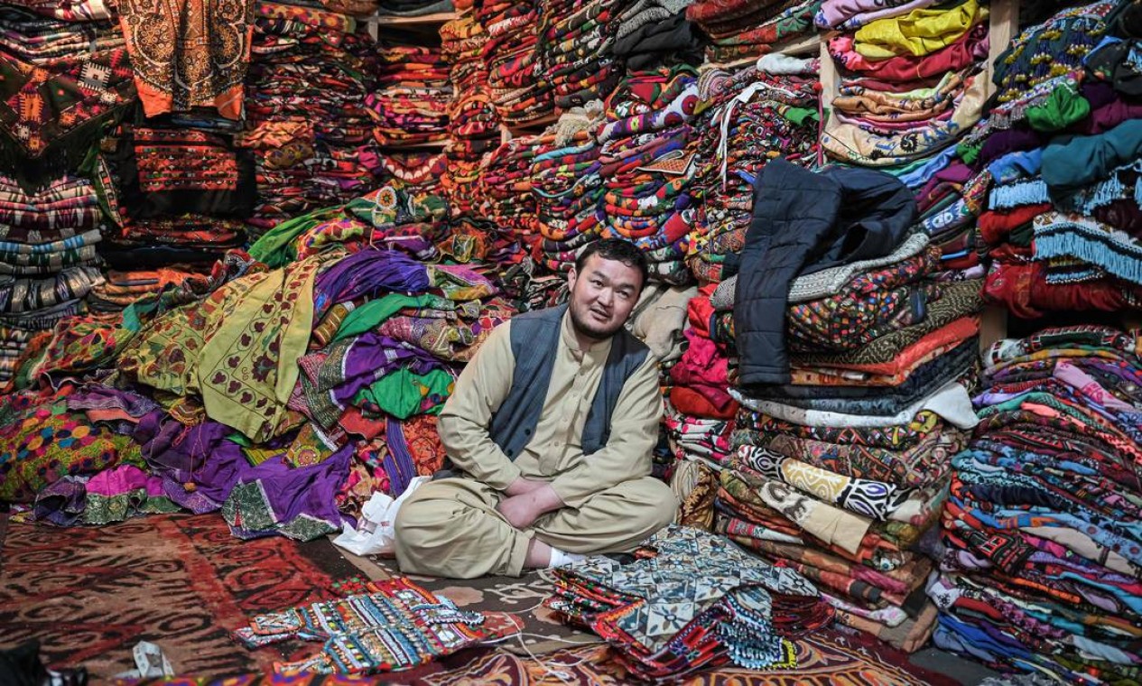 Vendedor de roupas e tecidos em sua loja enquanto, em Cabul Foto: MOHD RASFAN / AFP