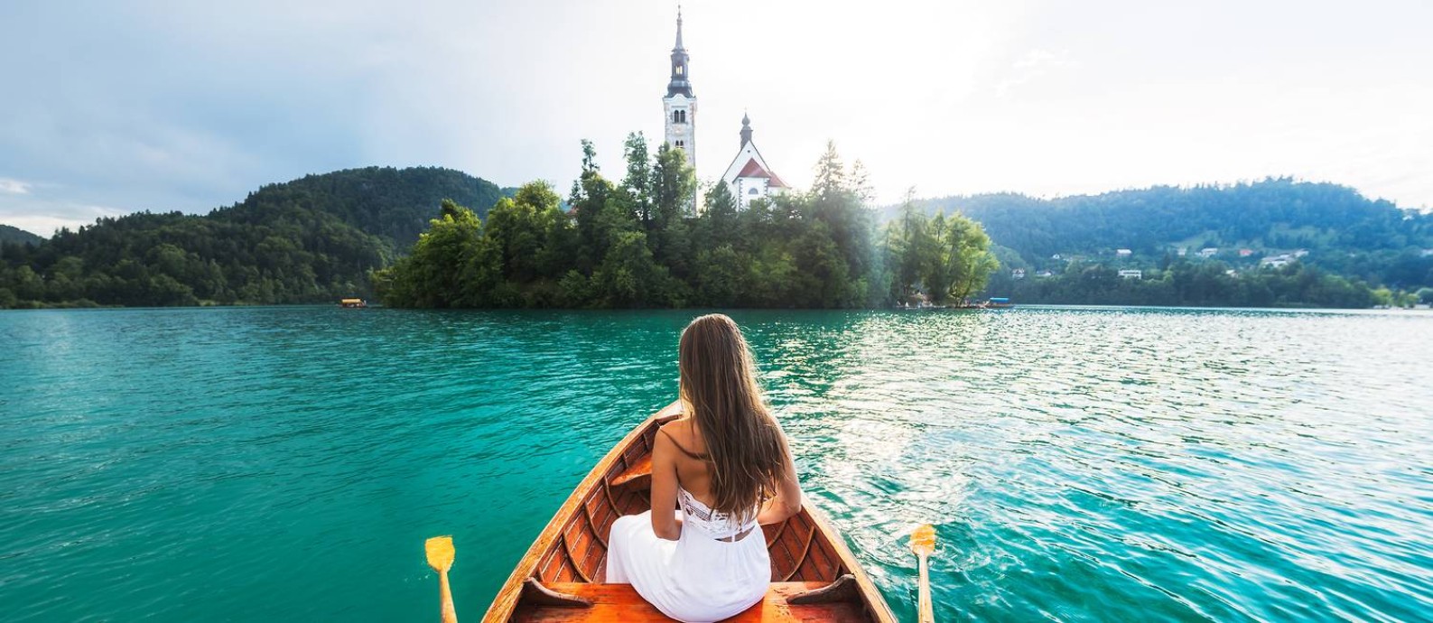 Visitante a bordo de uma pletna, barquinho típico da Eslovênia, no Lago Bled Foto: Turismo da Eslovênia / Divulgação