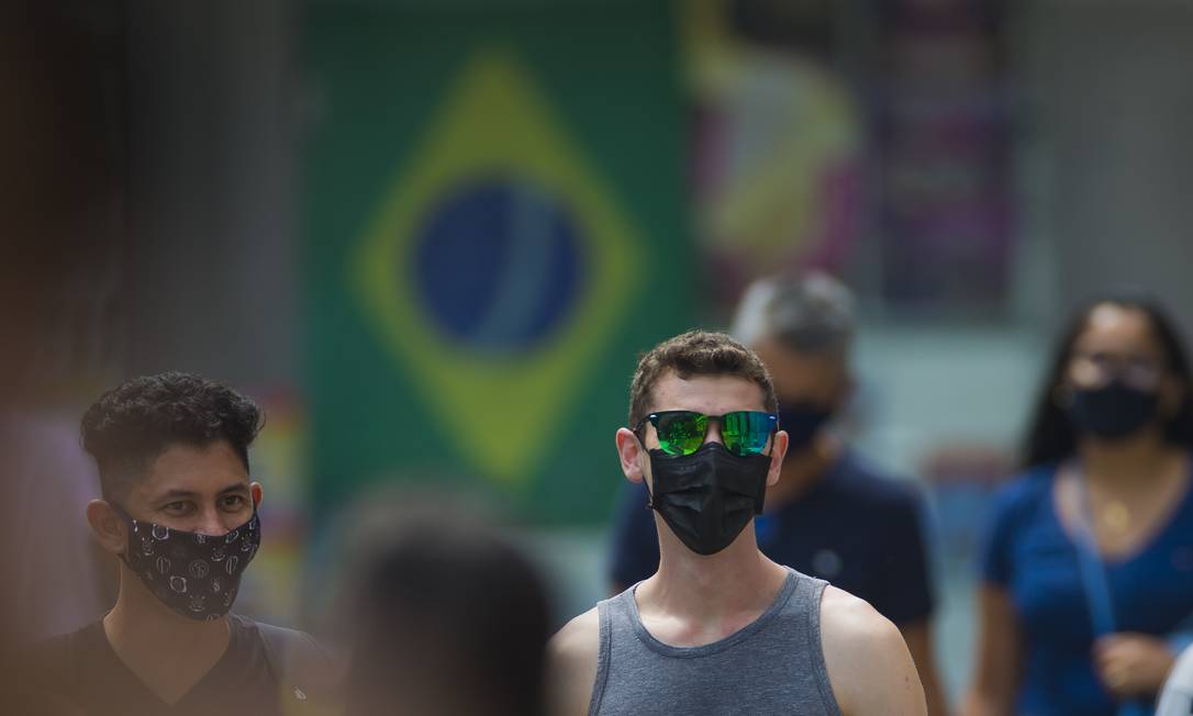 Pessoas caminham por São Paulo de máscaras: pico da onda provocada pela ômicron deve ocorrer em algumas semanas Foto: Edilson Dantas / Agência O Globo