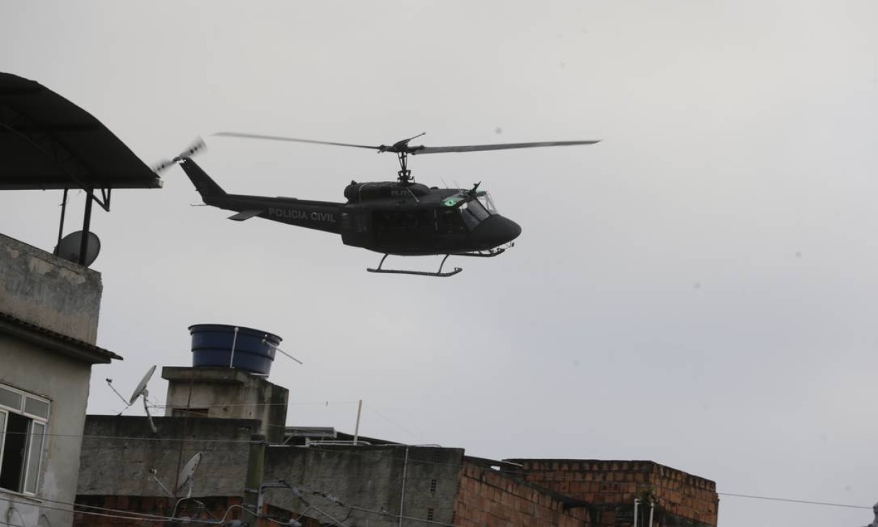 Pelo alto, um helicóptero dá apoio à operação que eleva o nível de tensão na comunidade Foto: Marcia Foletto / Agência O Globo