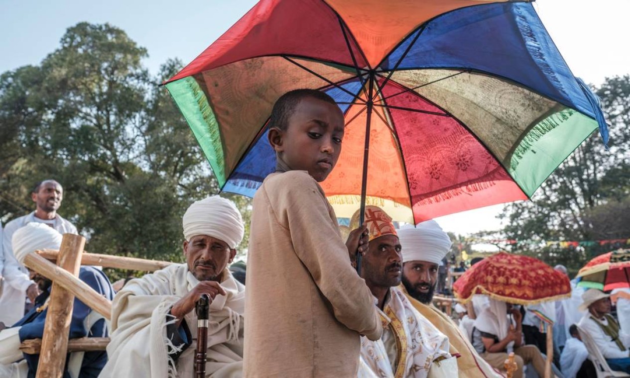 Criança etíope segura guarda-chuva durante a véspera da celebração ortodoxa de Timkat, a Epifania Etíope, na cidade de Gondar, Etiópia Foto: EDUARDO SOTERAS / AFP
