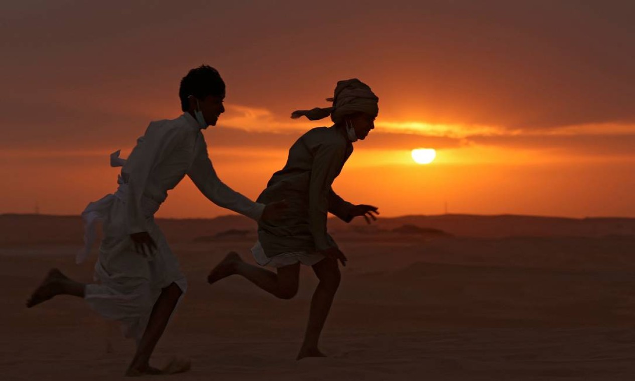 Crianças dos Emirados correm durante o Dhafra Camel Festival no deserto perto da cidade de Madinat Zayed, cerca de 150 km a oeste da capital Abu Dhabi Foto: KARIM SAHIB / AFP