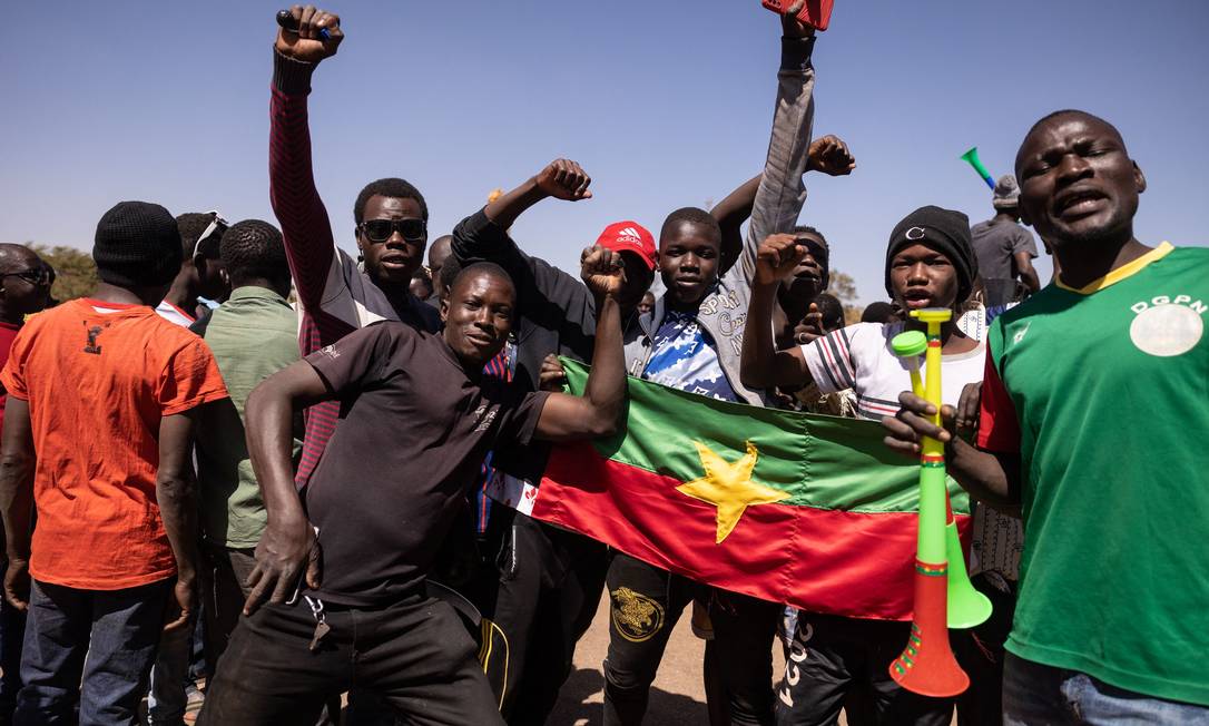 Moradores de Burkina Faso com bandeira do país vão às ruas da capital Uagadugu para apoiar os militares Foto: OLYMPIA DE MAISMONT / AFP