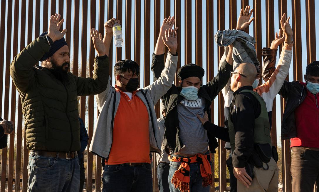 Migrantes de origem indiana são revistados pela polícia americana no Arizona, depois de terem cruzado a fronteira mexicana Foto: GO NAKAMURA / REUTERS/23-01-2022