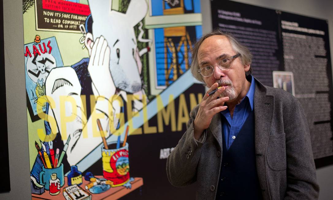 O quadrinista Art Spiegelman posa em uma exposição com um painel que mostra um trecho de sua obra Maus Foto: BERTRAND LANGLOIS / AFP