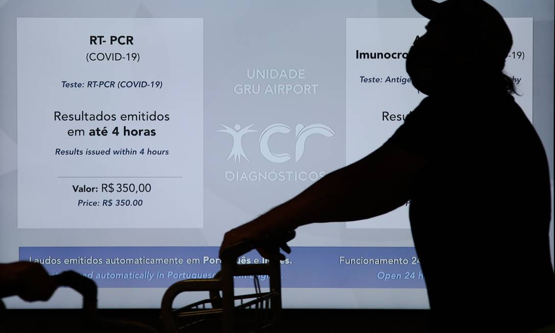 Passageiro passa em frente a uma tabela com preços de teste para Covid-19 no Aeroporto Intermacional de Guarulhos, em São Paulo Foto: Edilson Dantas / Agência O Globo