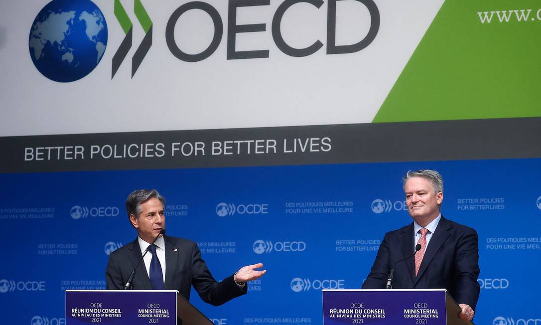 À direita, o secretário-geral da OCDE, Marthias Cormann, ao lado do secretário de Estado americano, Antony Blinken. Foto: IAN LANGSDON / AFP