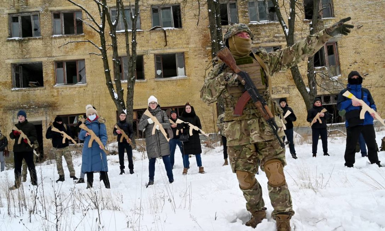Civis participam de treinamento militar com réplicas de madeira de fuzis em uma fábrica abandonada na capital ucraniana de Kiev Foto: SERGEI SUPINSKY / AFP