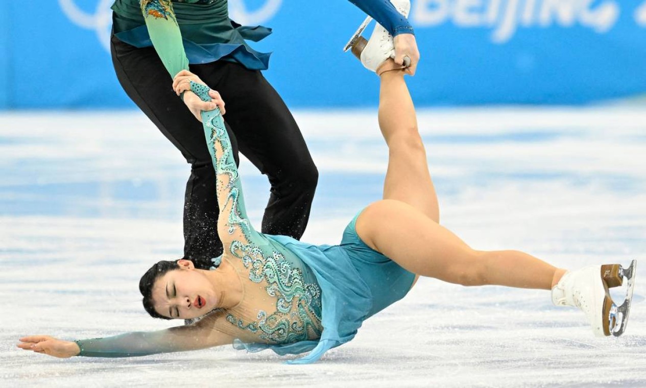Momento em que a dançarina de patinação artística da delegação chinesa, Wang Shiyue, é segurada pelo seu parceiro Liu Xinyu durante manobra que a deixa a poucos centímetros do solo, durante os Jogos de Inverno Foto: WANG ZHAO / AFP